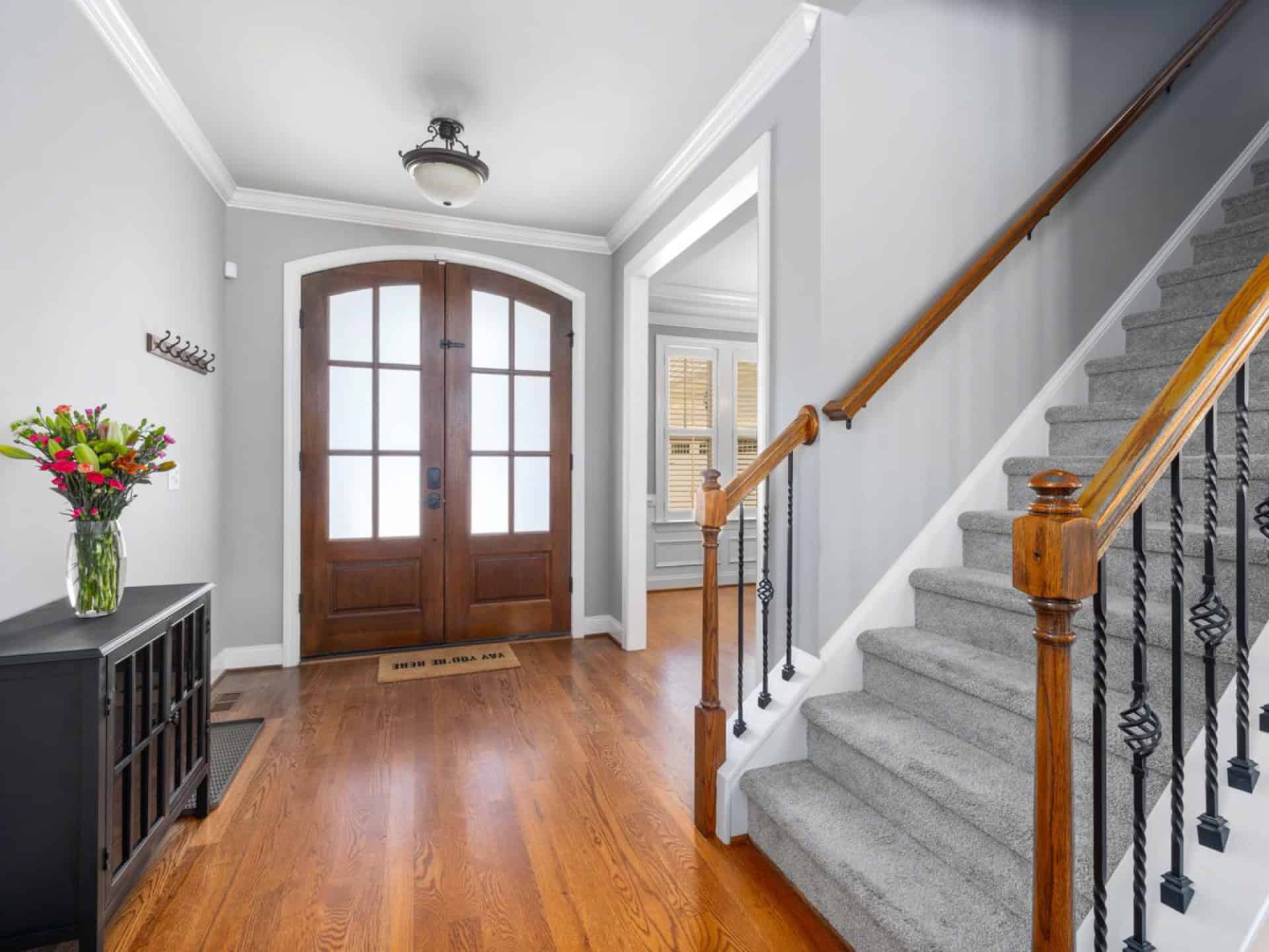 Arched wood double entry door with divided glass lites in a trimmed foyer — door installation